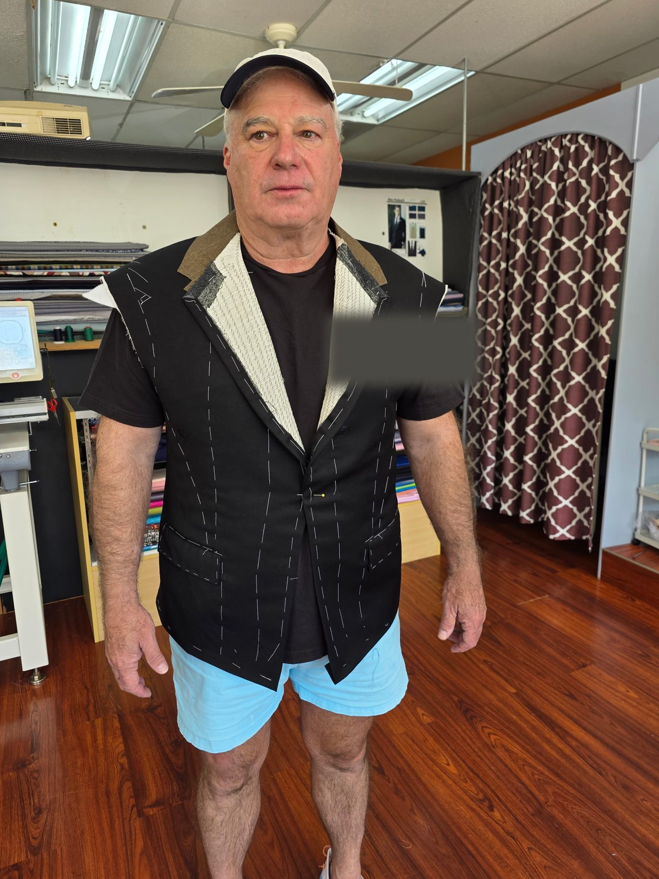 Another client mid-fitting in a hand-basted jacket, raw canvas visible, at GM Custom Clothier in Sugar Land, TX